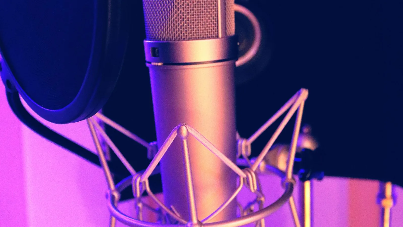 A studio microphone in purple light