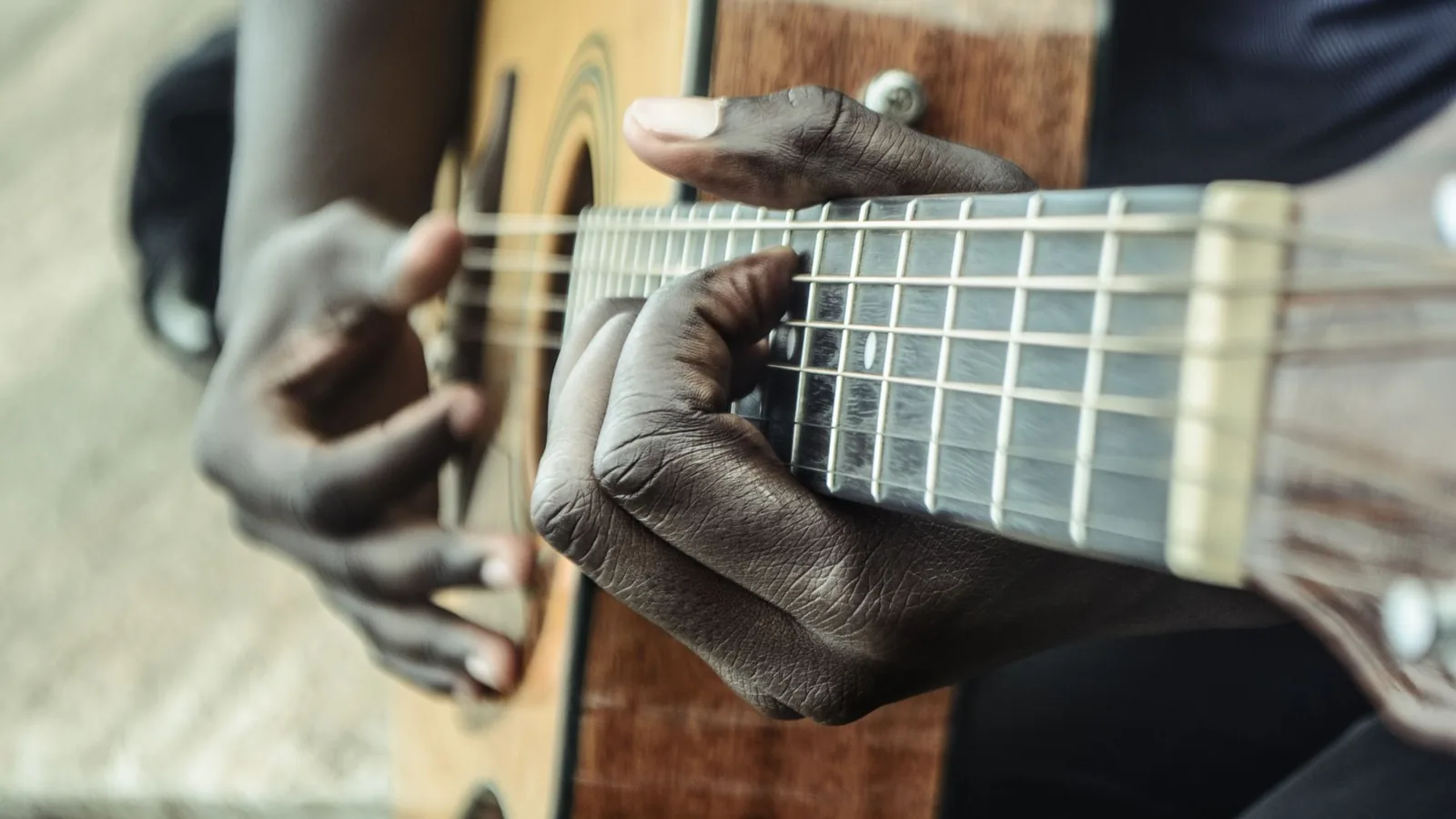 Hands playing an acoustic guitar