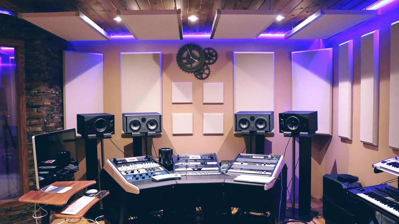 A recording studio with a mixing desk and monitors