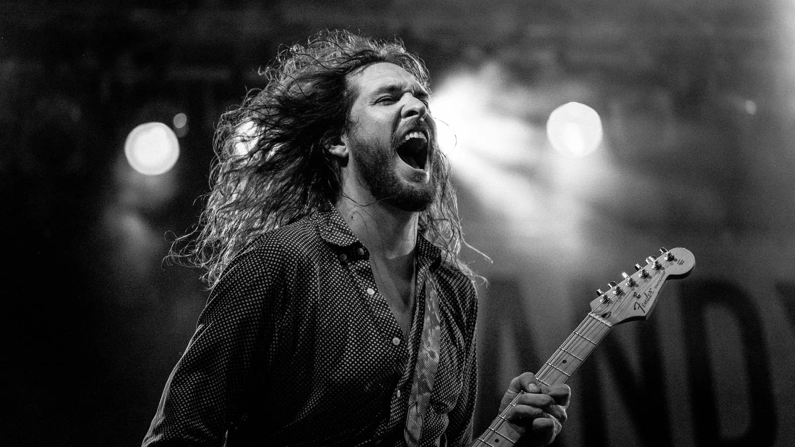 A guitarist in a black-and-white photo